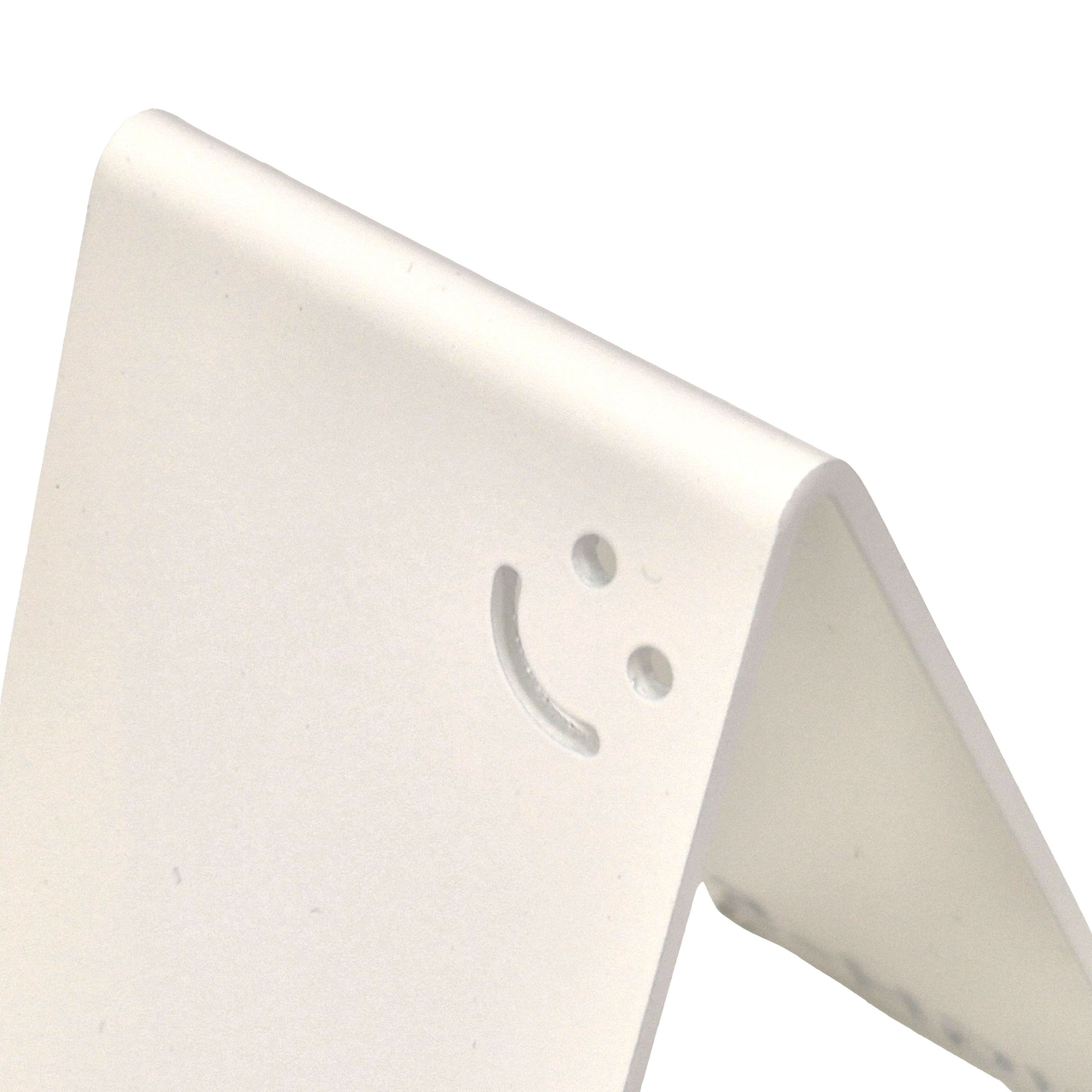 Weiß Metall-Handyhalter von Highfive Engineering auf einem Schreibtisch, für ein Smartphone in aufrechter Position Smiley